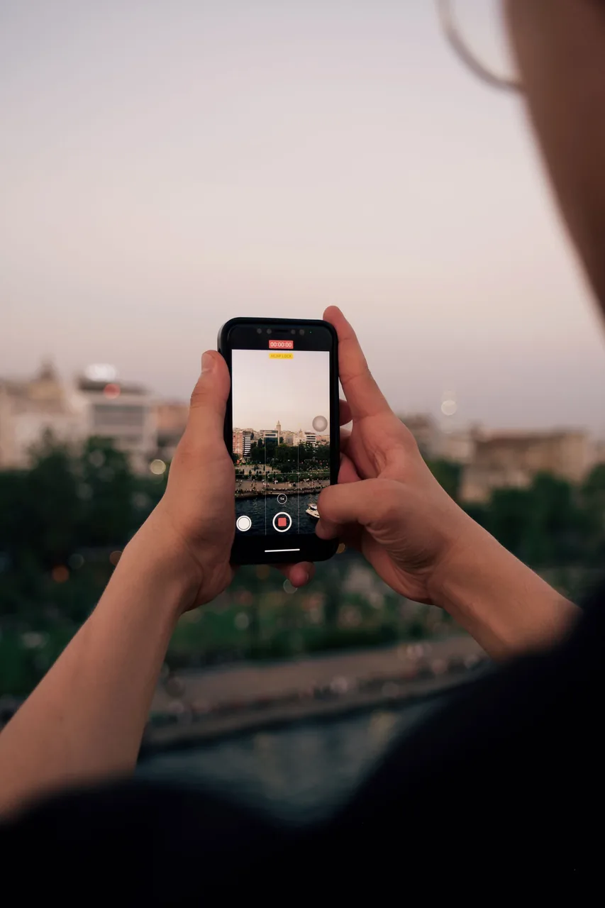 Tatilde telefonla manzara fotoğrafı çeken eller